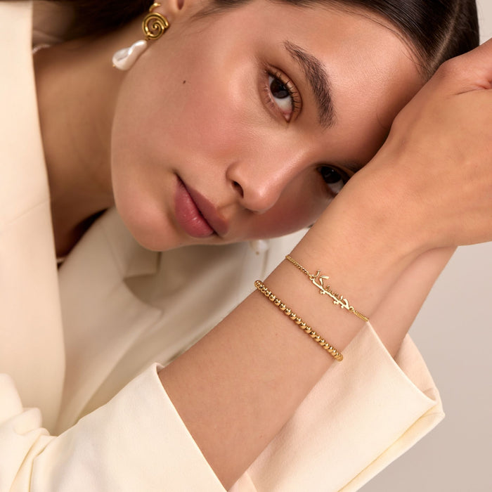 model wearing arabic name bracelet and lena sphere beaded bracelet in gold from prya