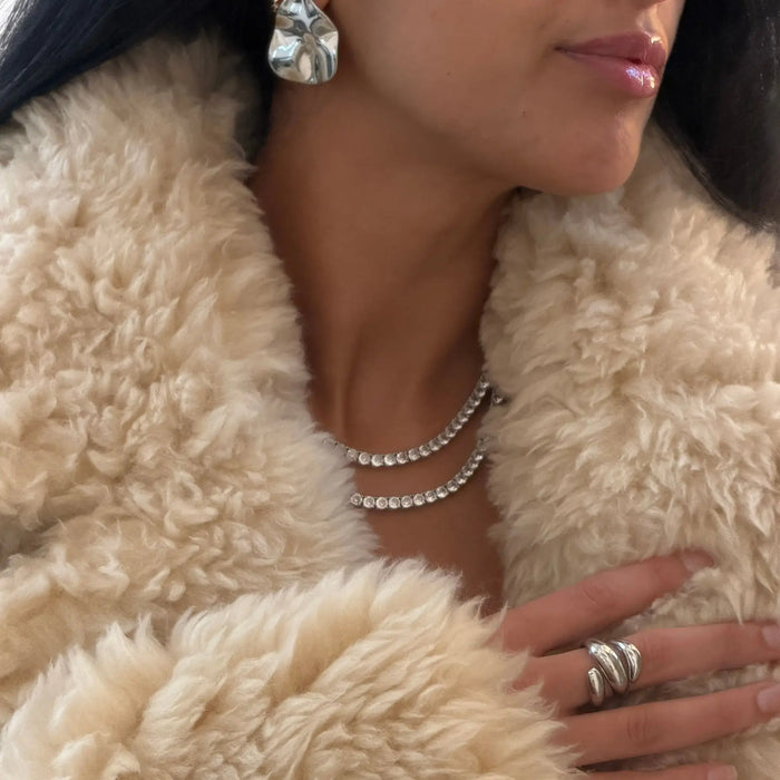 model wearing Icy Tennis CZ Necklace in silver and silver statement earrings and chunky ring made by Prya