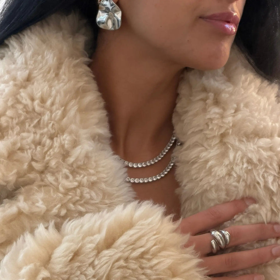 model wearing Icy Tennis CZ Necklace in silver and silver statement earrings and chunky ring made by Prya