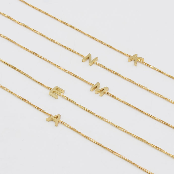 Maia Initial Bracelets featuring gold link chains with letter pendants for personalised elegance.