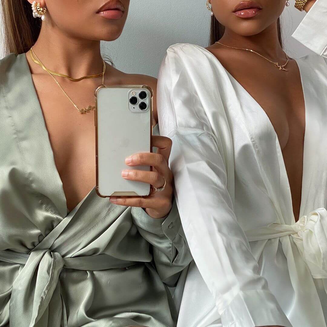 Two women wearing silk dressing gowns and Arabic name necklaces