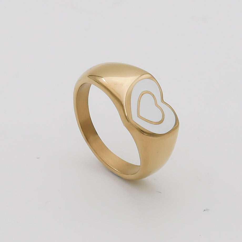 Gold ring with white heart design.