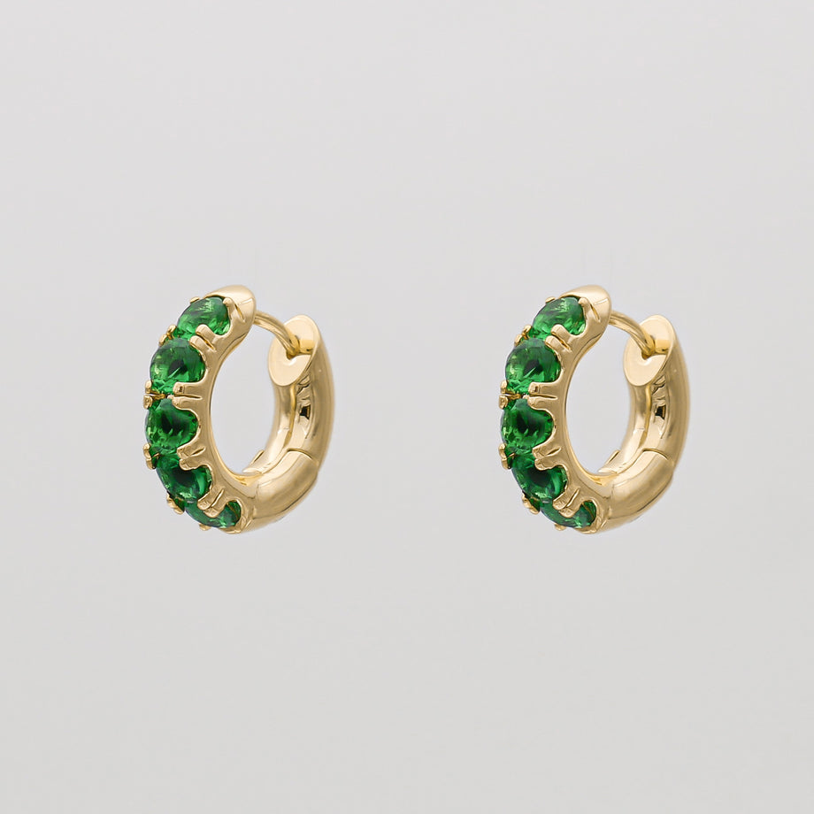 Gold hoop earrings with green gemstones.