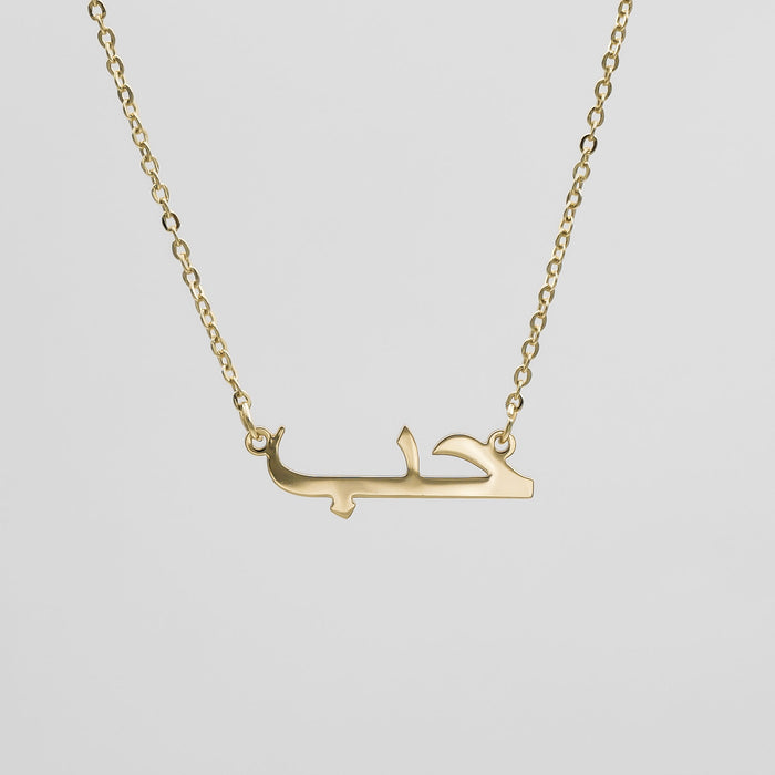 Gold necklace with Arabic script pendant.