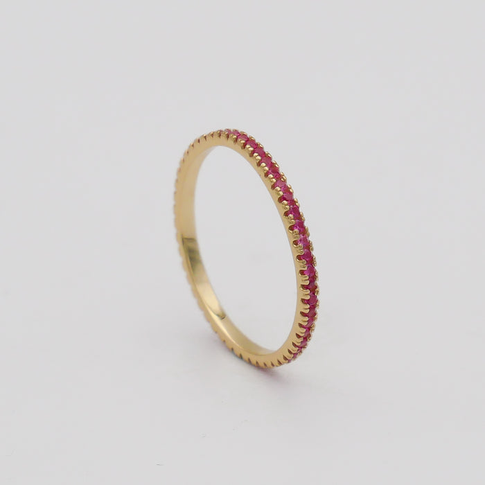 Gold ring with small pink gemstones.