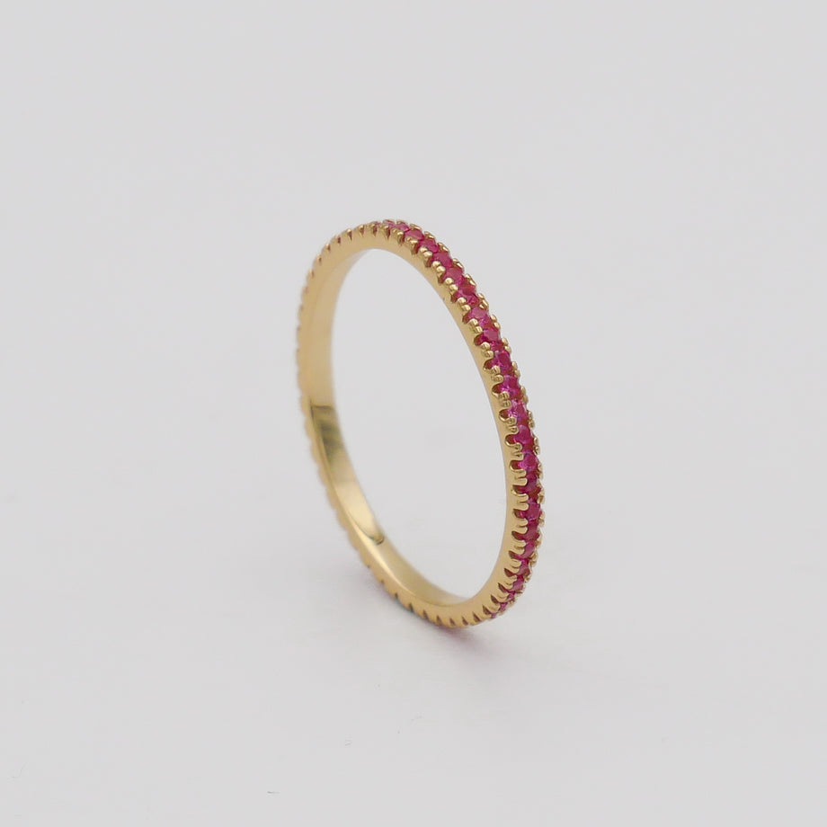 Gold ring with small pink gemstones.