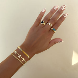 Hand model wearing  our Classic custom name bracelet and other Prya jewelley