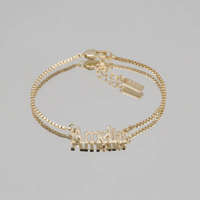 Gold name bracelet with "Amelia" inscription.