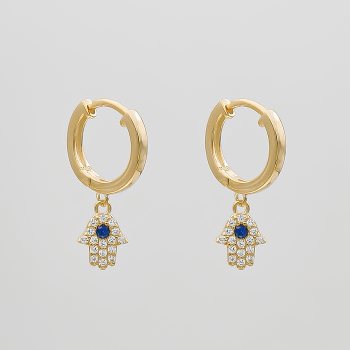 Gold earrings with Hamsa hand charms.