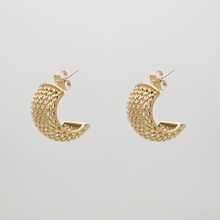 Gold textured hoop earrings on white background.