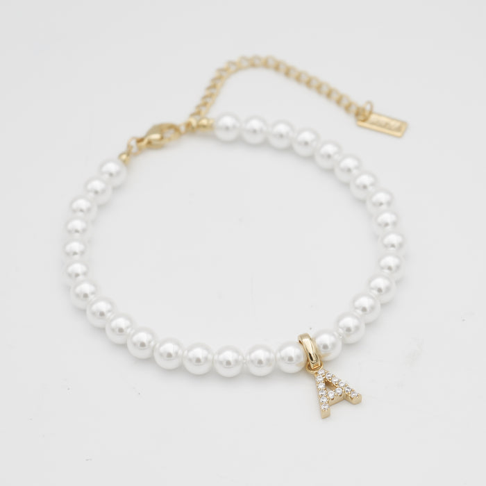 Pearl anklet with gold initial "A" charm.