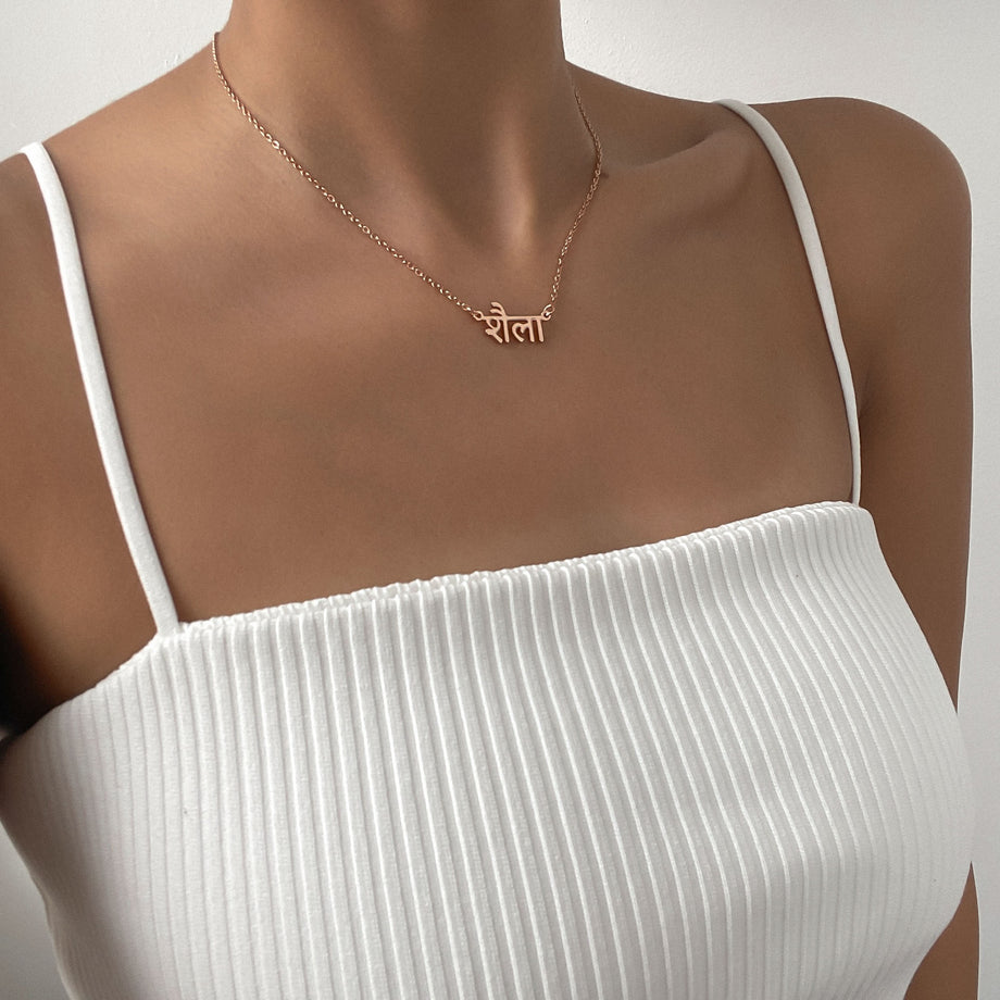 A woman modelling a rose gold Hindi name necklace