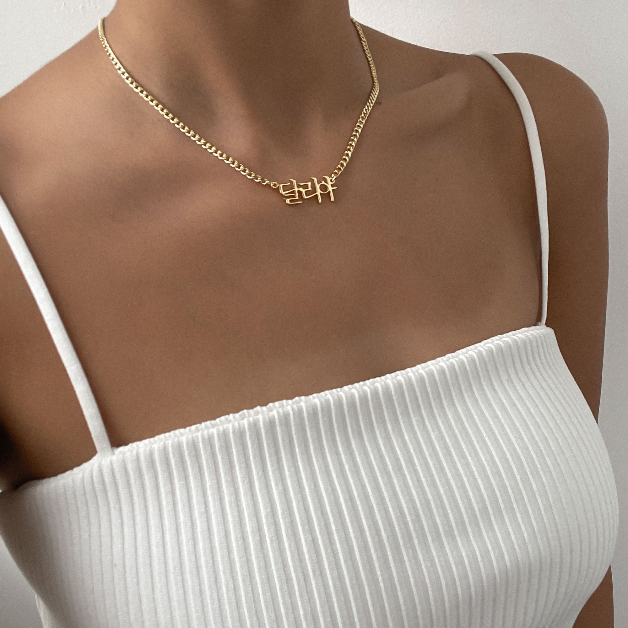 Gold Korean name necklace worn around a woman’s neck