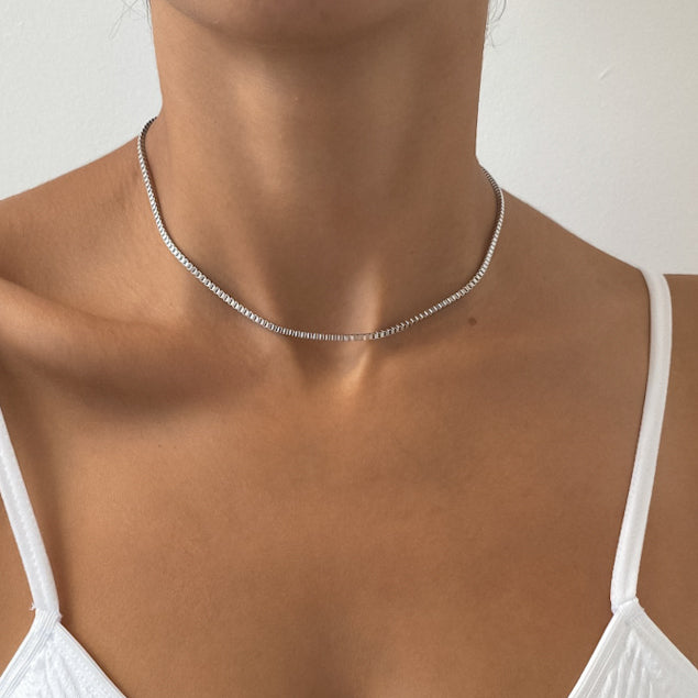 Woman wearing a delicate silver necklace.