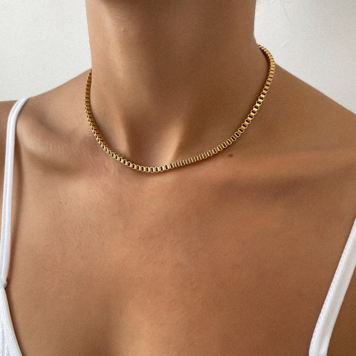 Gold chain necklace on a person's neck.