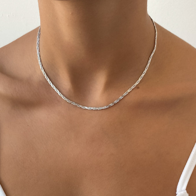 Silver necklace on a person's neck.