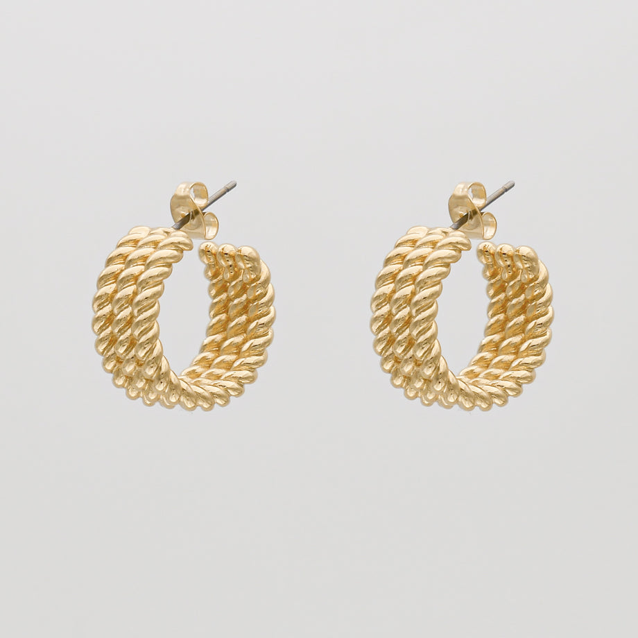 Gold twisted hoop earrings on white background.