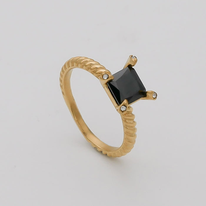 Gold ring with black square gemstone.