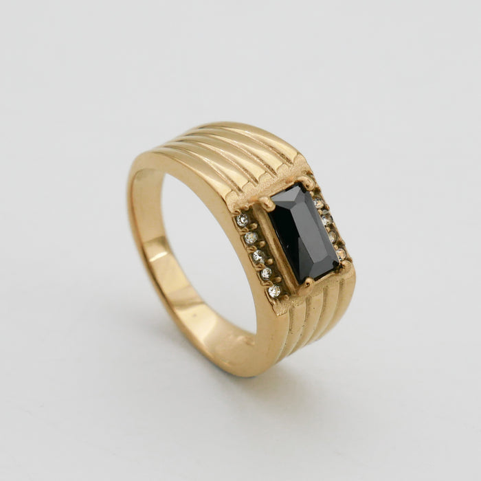 Gold ring with black stone and diamond accents.