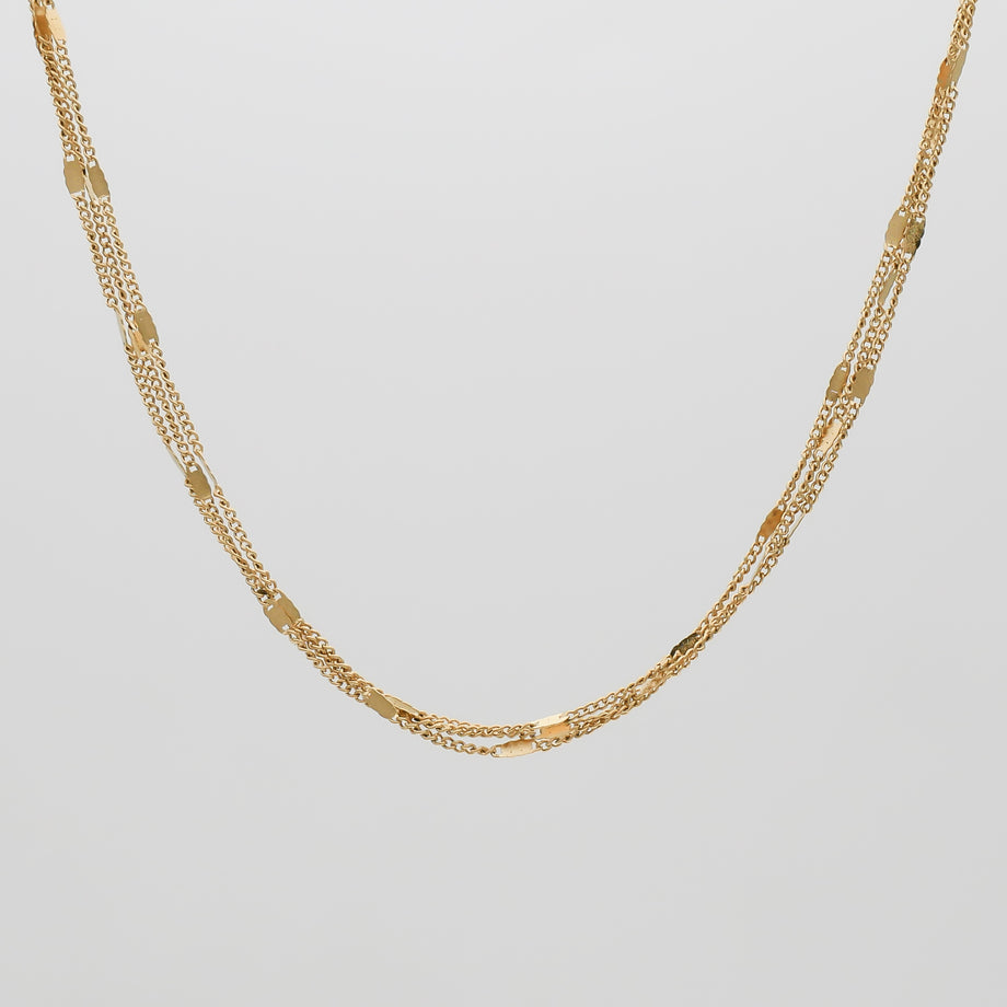 Gold chain necklace on white background.