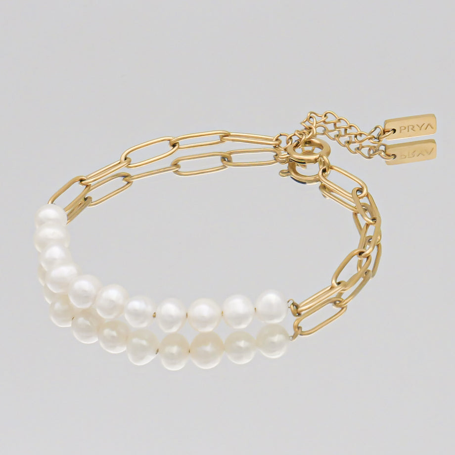 Gold chain bracelet with white pearls.