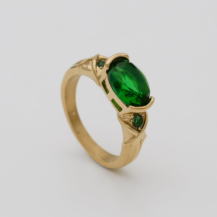 Gold ring with an oval emerald gemstone.