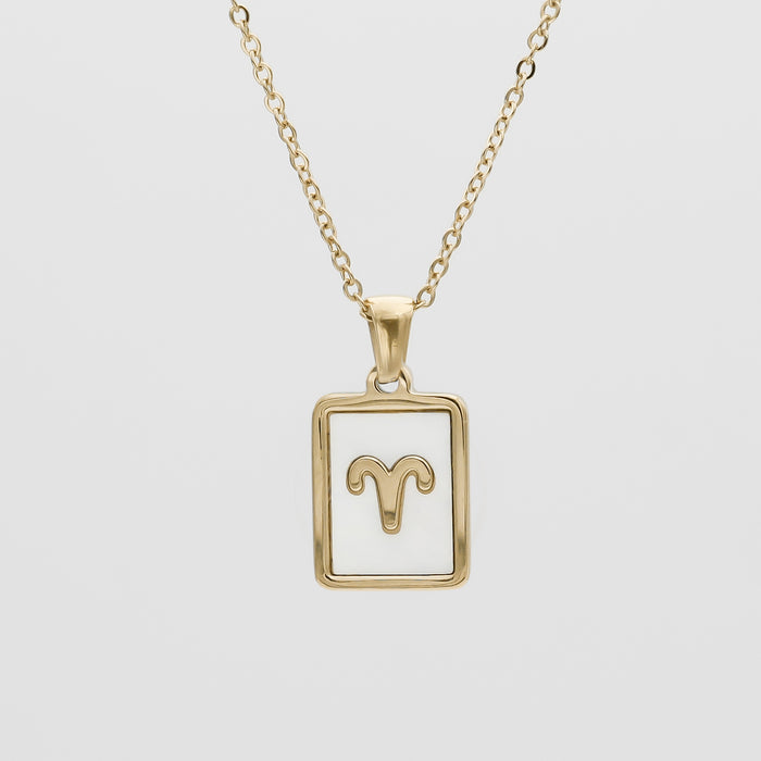 Gold Aries zodiac necklace on white background.