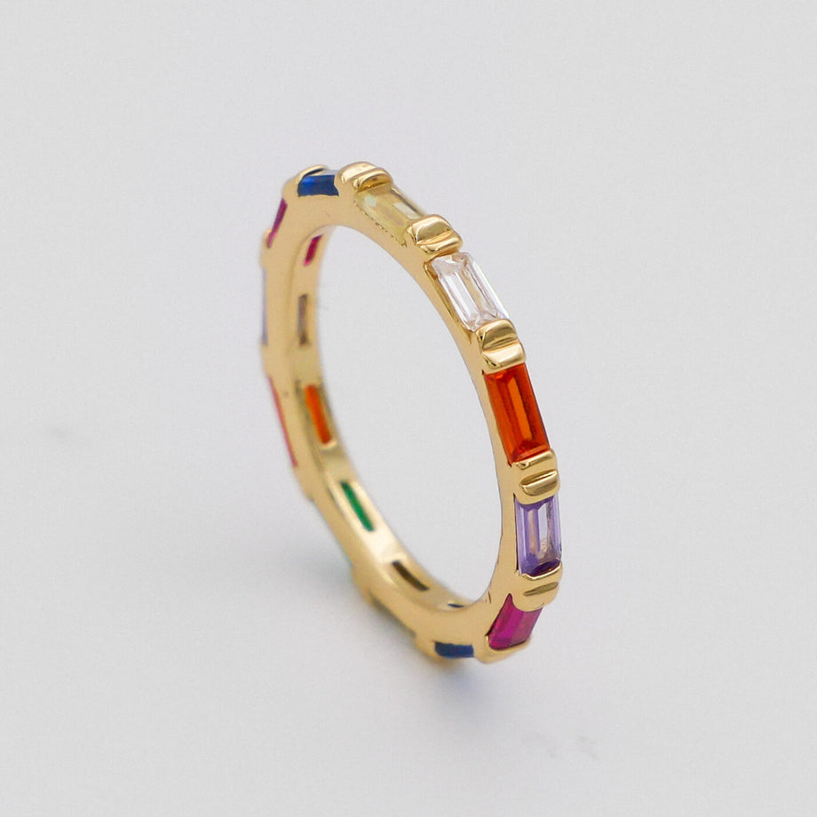 Gold ring with multicoloured baguette gemstones.