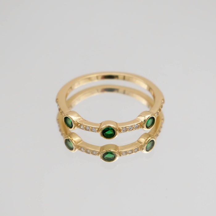 Gold ring with green stones and diamond accents.