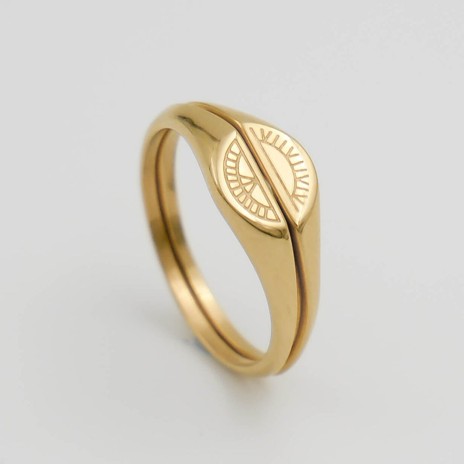 Gold ring with engraved sun and moon design.