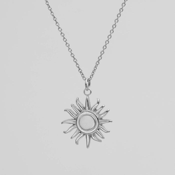 Silver sun pendant necklace on chain.