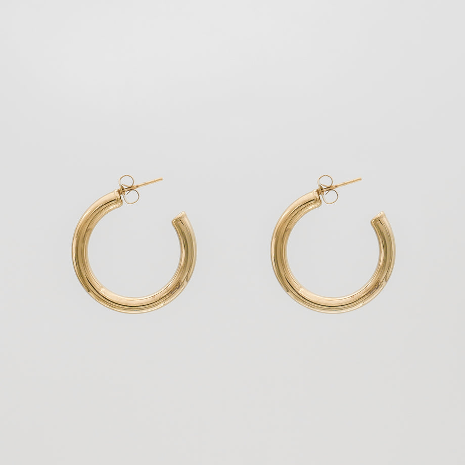 Gold hoop earrings on a plain background.