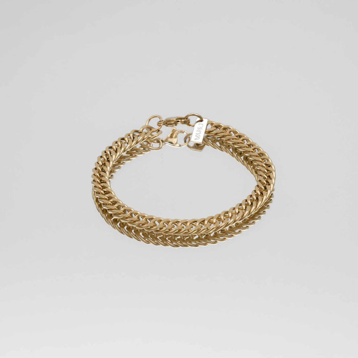 Gold chain bracelet on a grey background.