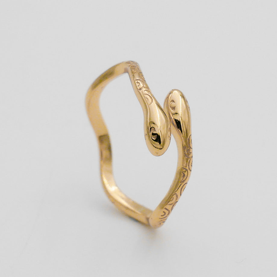 Gold snake-shaped ring with engraved details.