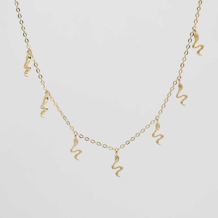 Gold necklace with dangling snake charms.