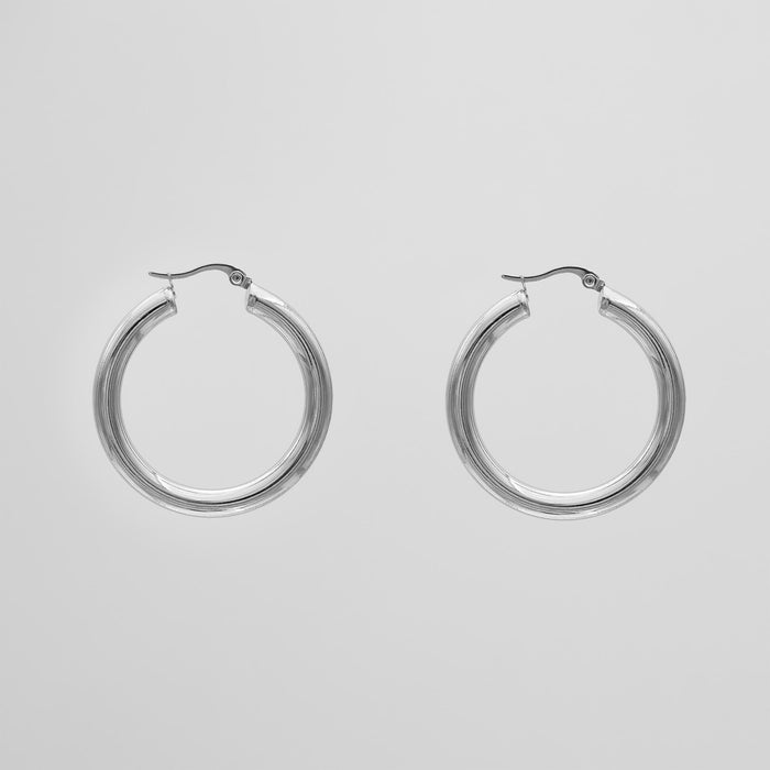 Silver hoop earrings on a plain background.