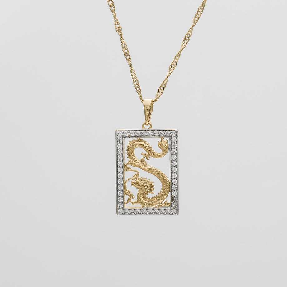 Gold dragon pendant with diamond border on chain.