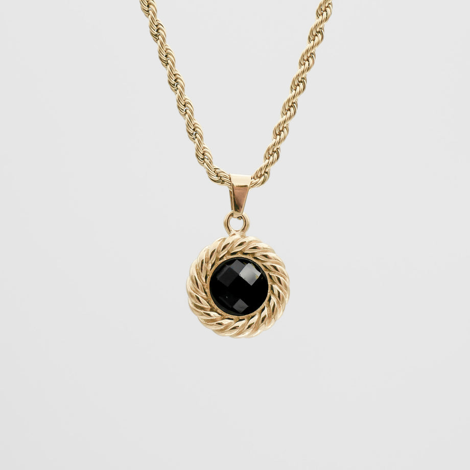 Gold necklace with black gemstone pendant.