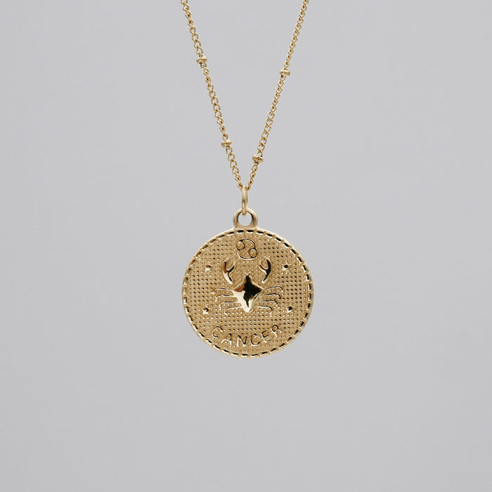 Gold Cancer zodiac pendant on chain necklace.