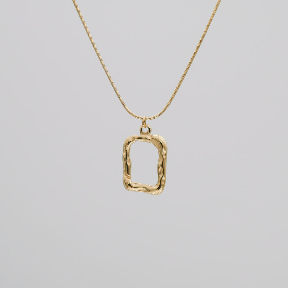 Gold pendant necklace on a thin chain.