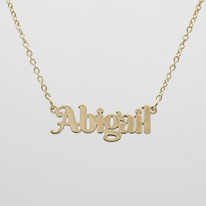 Gold necklace with "Abigail" name pendant.