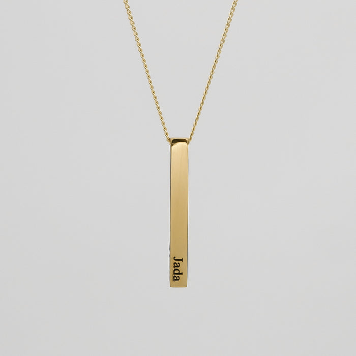 Gold bar pendant necklace with engraved name.