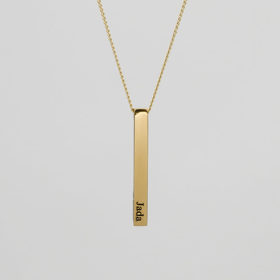 Gold bar pendant necklace with engraved name.