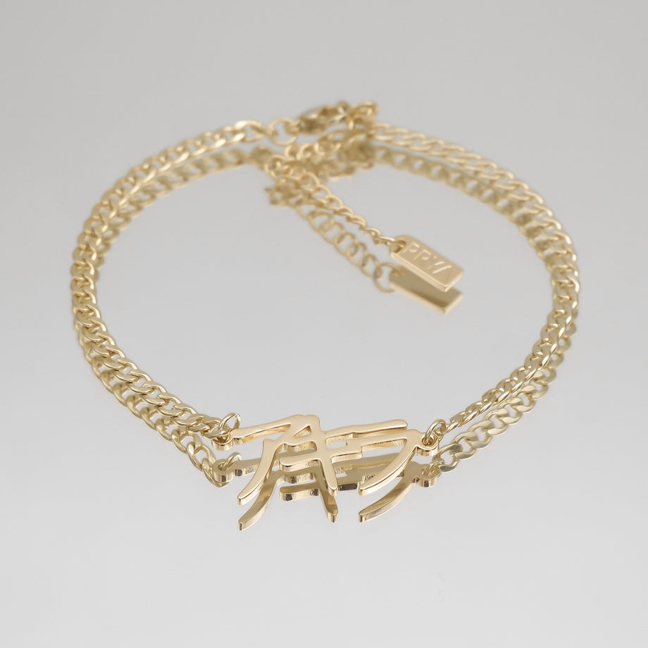 Gold chain anklet with custom name charm.