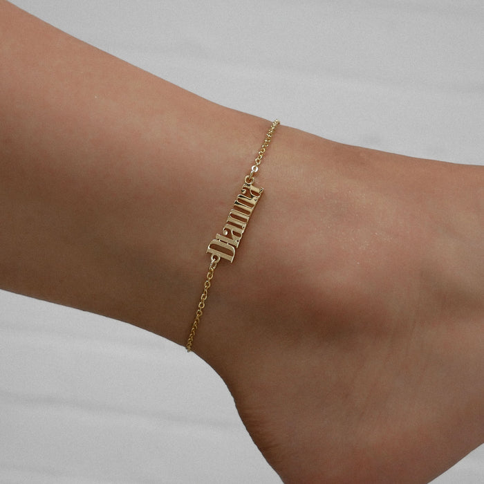 Model wearing custom name anklet in gold from prya