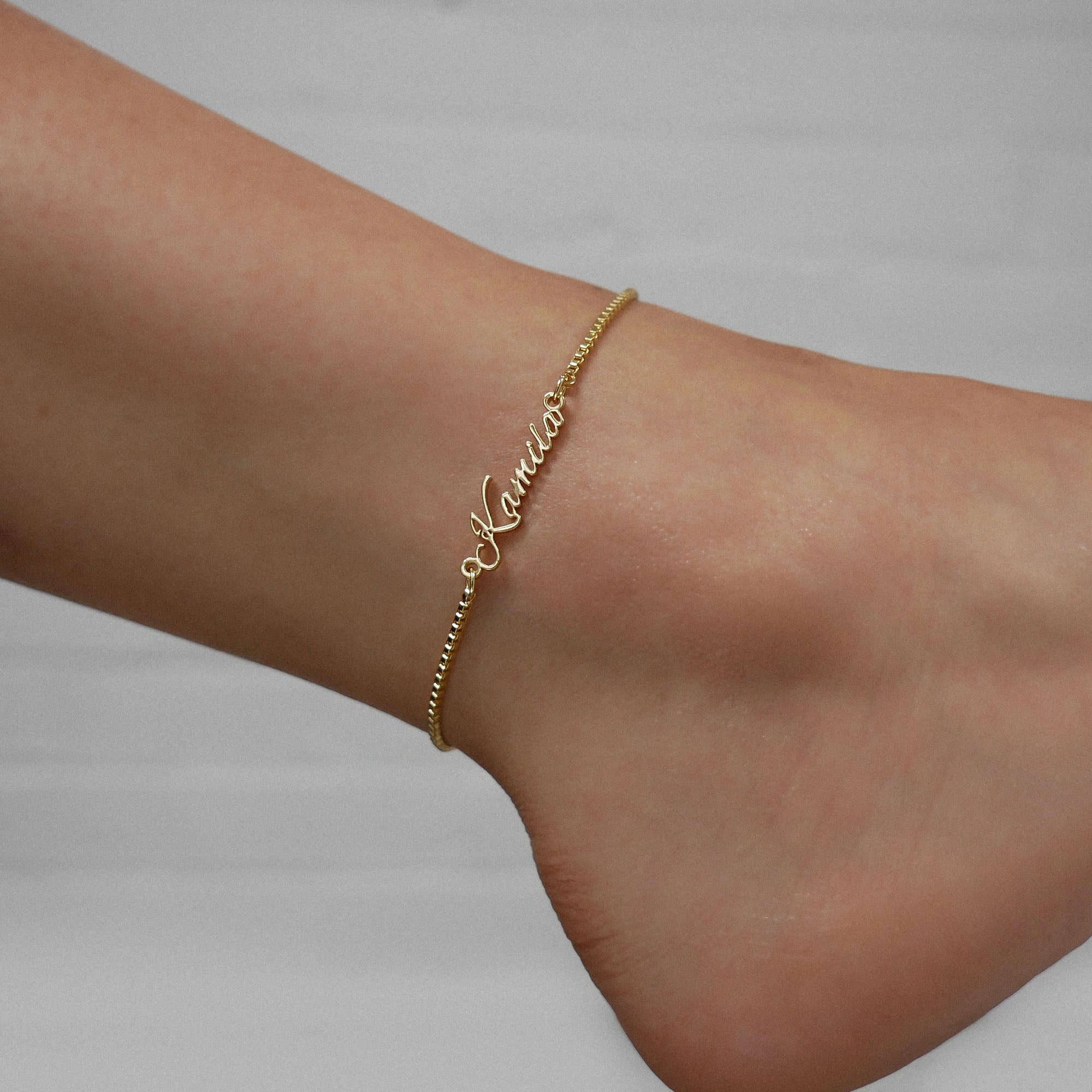 Gold Venice custom name anklet photographed on an ankle