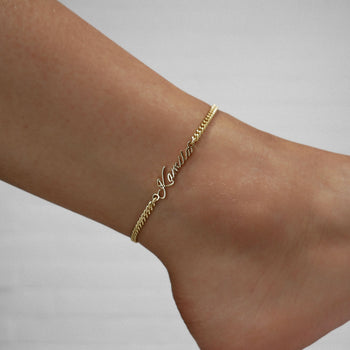 Gold custom name anklet pictured on an anklet