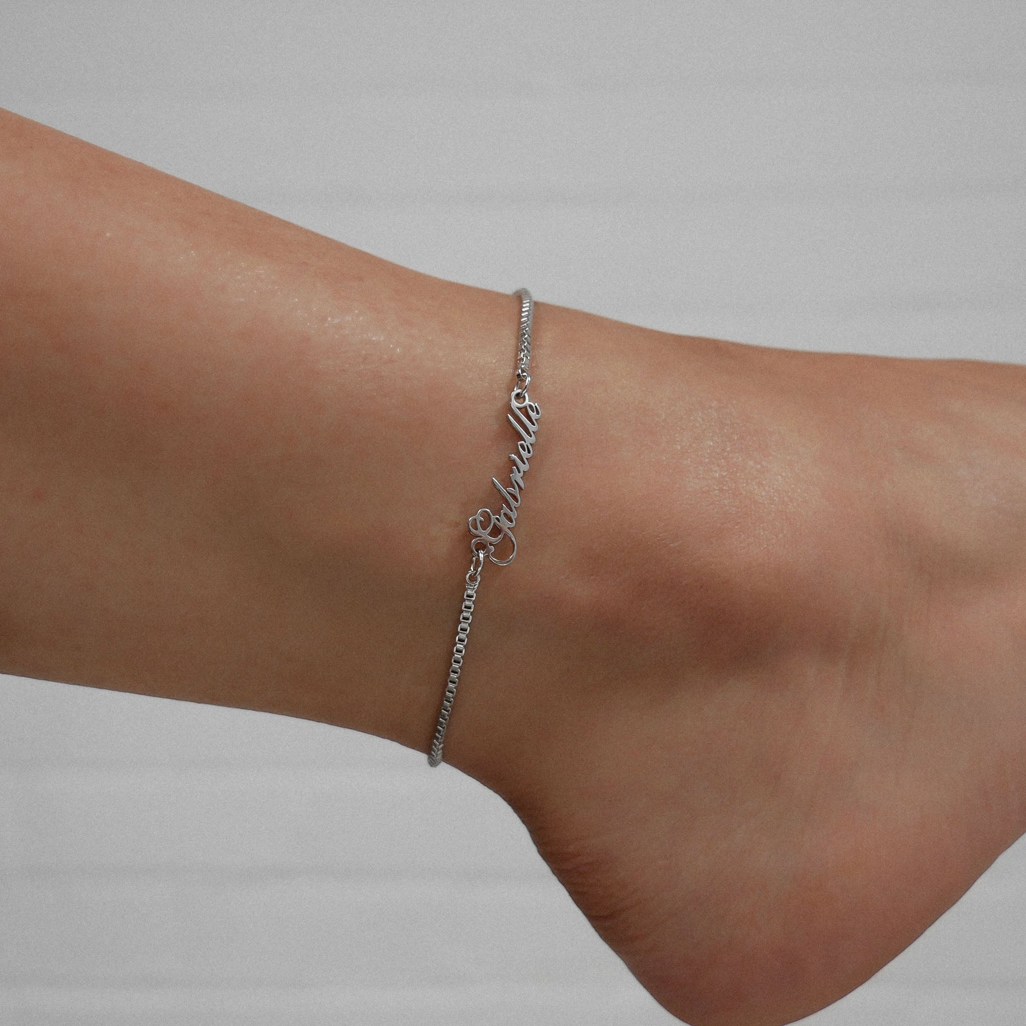 Silver custom name anklet displayed on an ankle