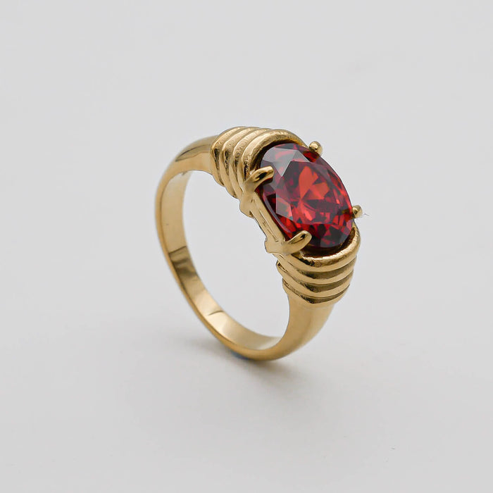 Gold ring with a large red gemstone.