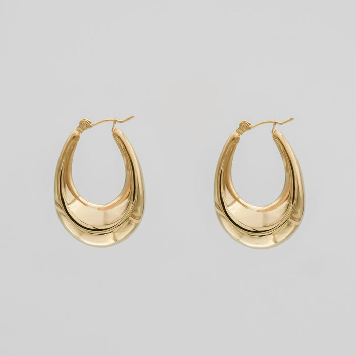 Gold hoop earrings on a plain background.